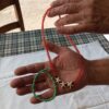 Κόκκινο κολιέ με χάντρες και τρεις λευκούς αστερίες, μαζί με βραχιόλι σε πράσινο και τιρκουάζ